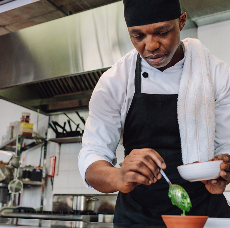 chef plating food in a high end commercial kitchen